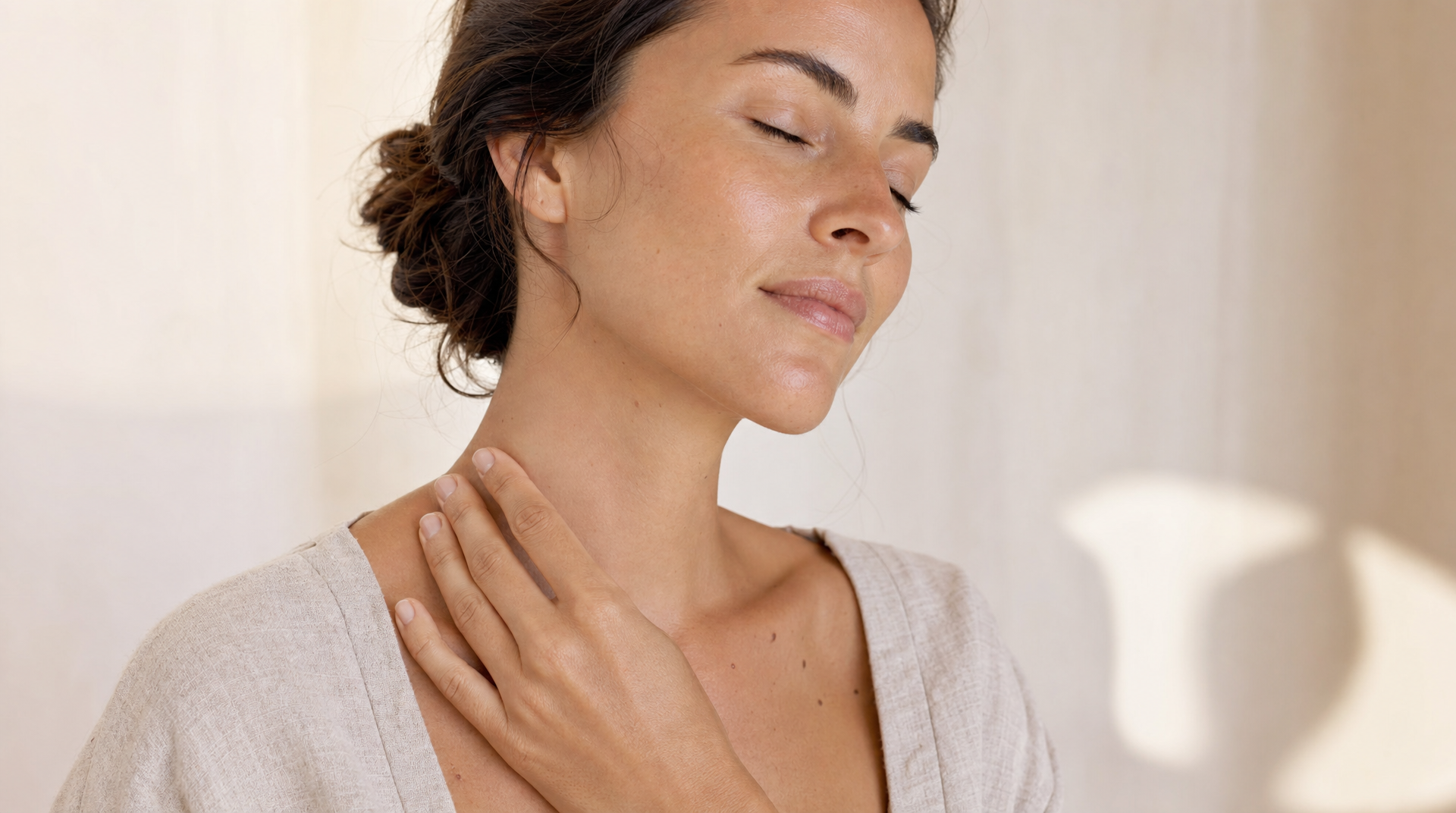Woman performing gentle self-lymphatic massage on neck toward collarbone